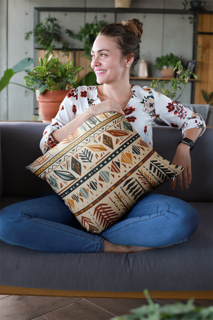 A woman sits on a couch and holds an Earth Tones Boho Tribal Pillow